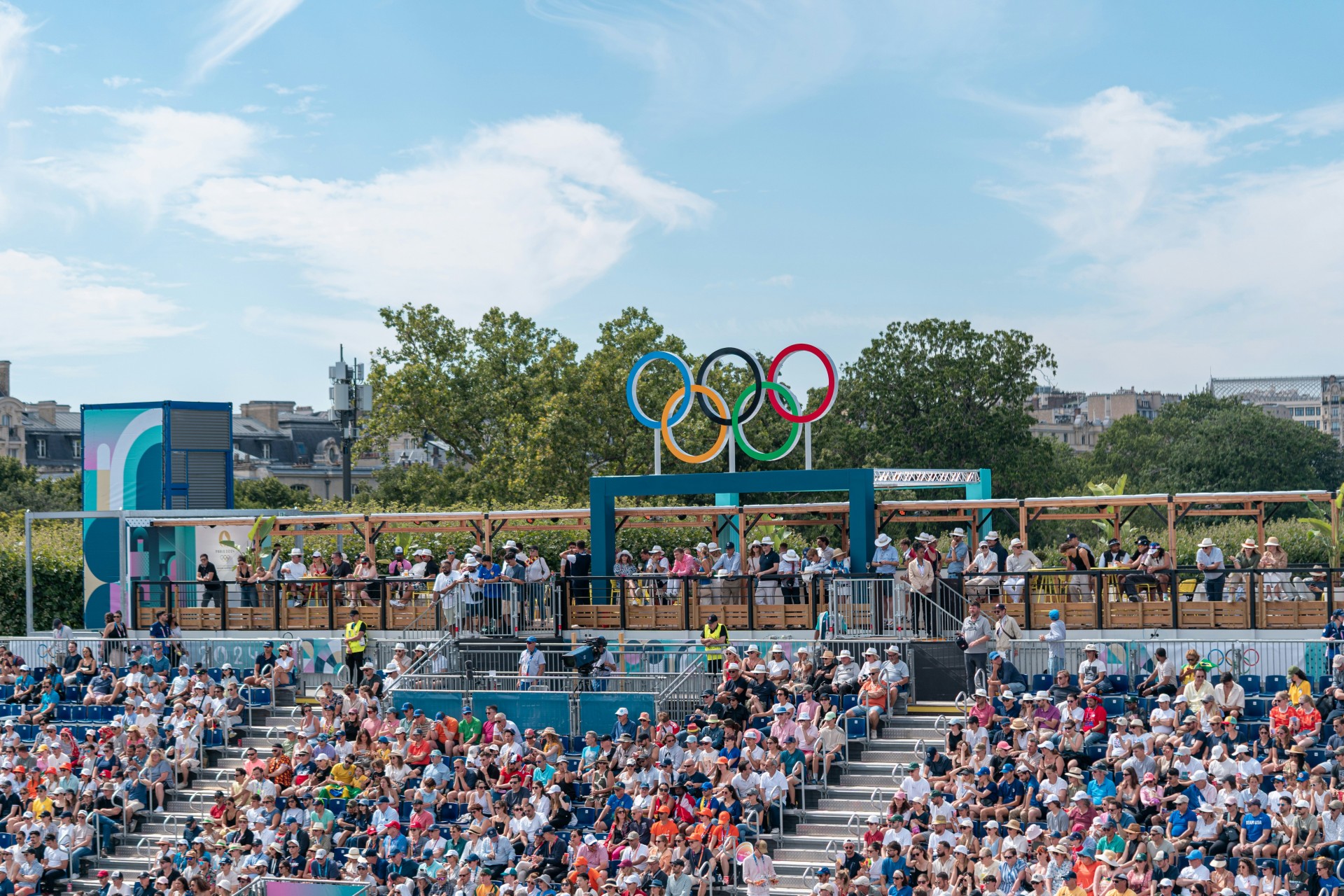 Anneaux Olympiques au-dessus de gradins remplis de personnes Paris 2024