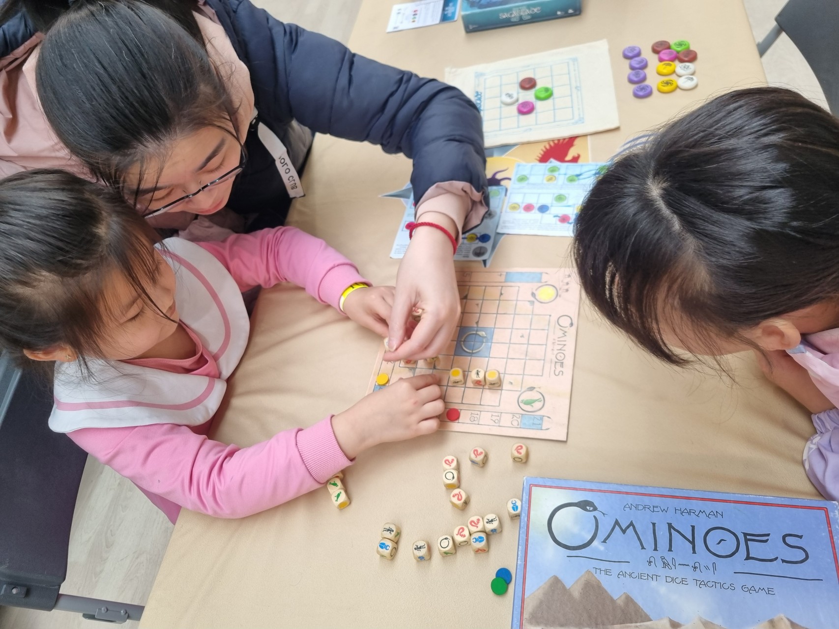 Une mère aide une enfant à jouer à Ominoes