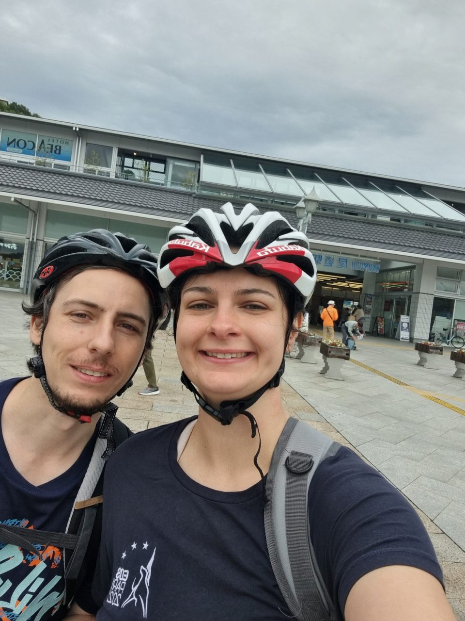 Florian et Fleur avec des casques de vélo sur la tête devant la gare d'Onomichi