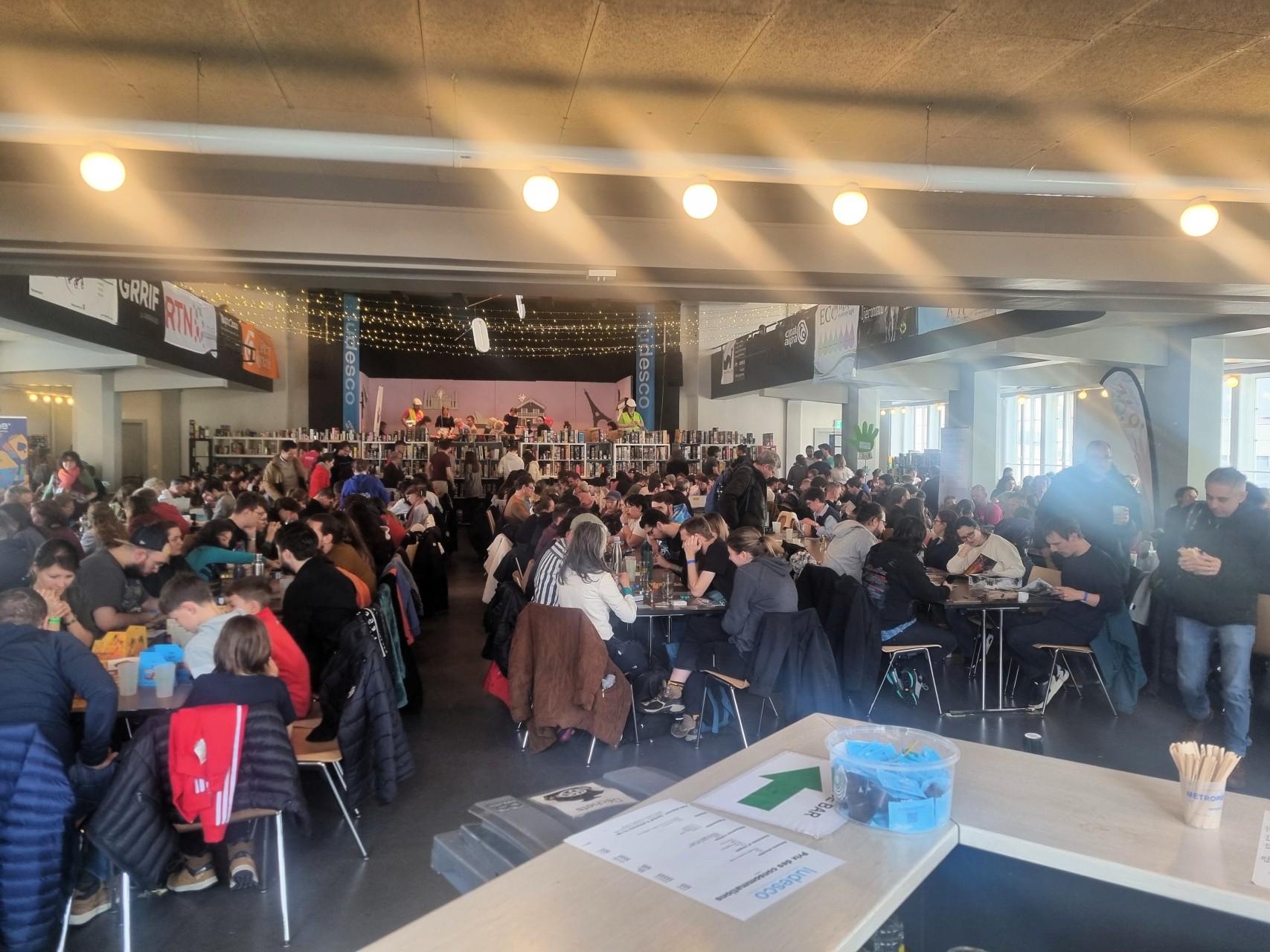Vue sur la grande salle bien remplie de joueurs depuis derrière le bar