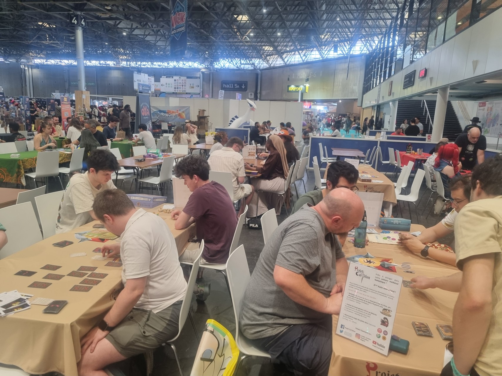 Deux tables de jeux avec nappes Projet CarTylion et des joueurs dessus