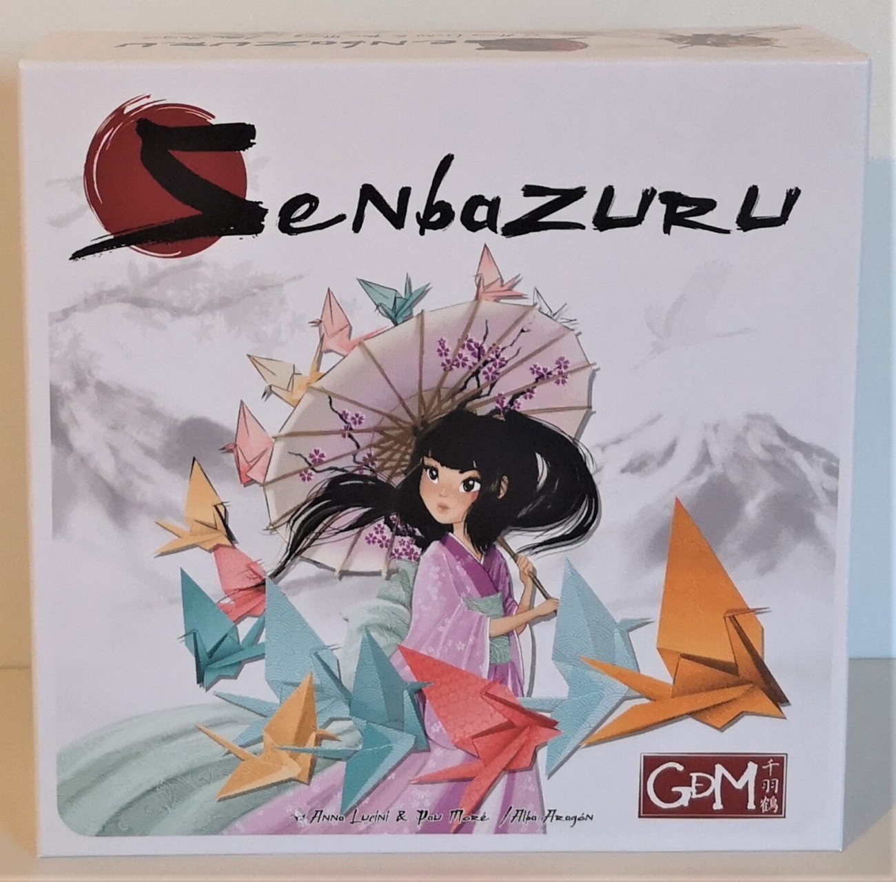 Boîte du jeu de société Senbazuru avec une femme japonsaise et des grues en origami